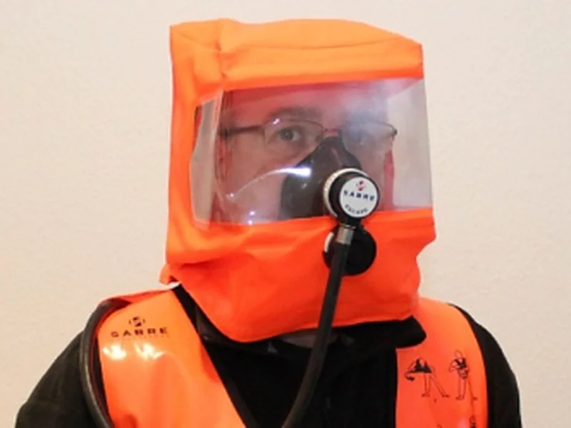 Beschäftigter mit angelegtem Flucht-Druckluftgerät mit Haube